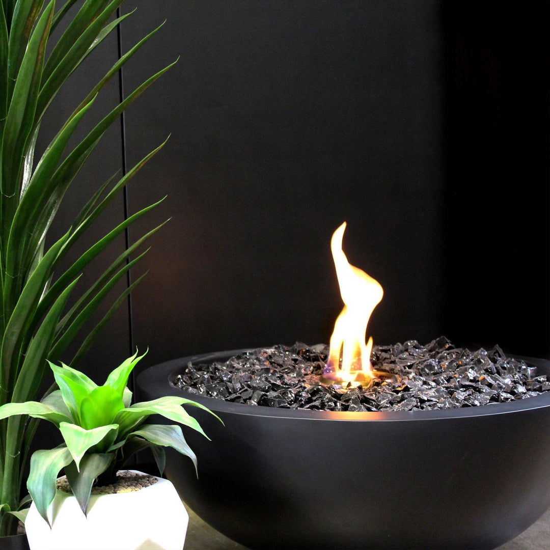 A close-up view of the EcoSmart Fire Mix 850 graphite fire pit, showcasing the sleek black fire bowl filled with reflective fire glass. The vibrant flames flicker elegantly, making this luxury fire pit a perfect addition to modern outdoor fire spaces and contemporary patios.