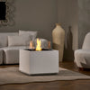 A lifestyle shot of the EcoSmart Fire Sidecar 24 placed in a bright white living room. The white finish complements the elegant and minimalistic dÃ©cor, creating a soothing ambiance. The fire pit is surrounded by cozy furniture, with the flames offering a warm and inviting atmosphere. Ideal for any stylish living room or lounge area. 