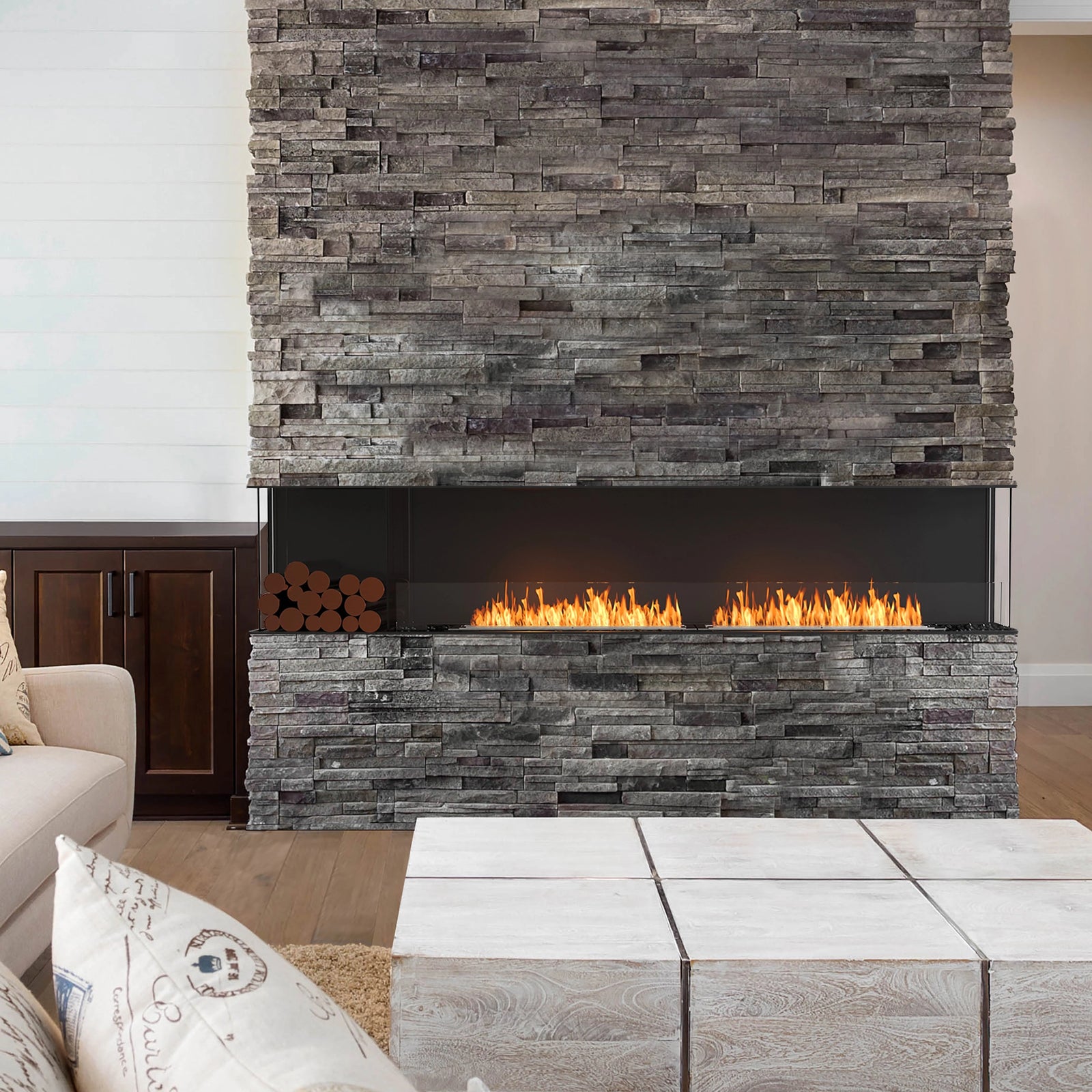 Modern linear fireplace set within a rustic stone wall, blending contemporary design with natural textures to create a warm and inviting living space
