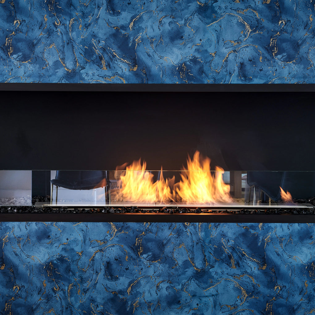 Modern fireplace with a blue and gold marbled background, featuring a sleek glass barrier and a vibrant flame, perfect for contemporary home decor