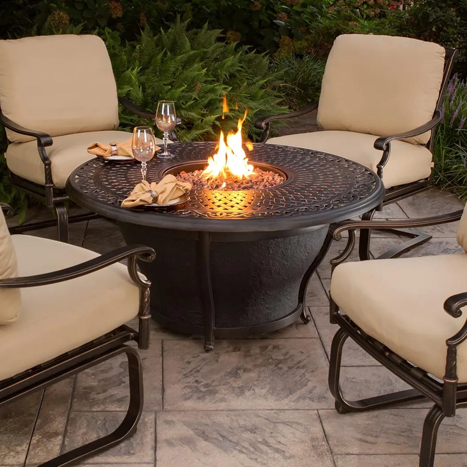 Elegant outdoor patio setup with a round fire pit table, surrounded by comfortable cushioned chairs, creating a cozy ambiance for evening gatherings