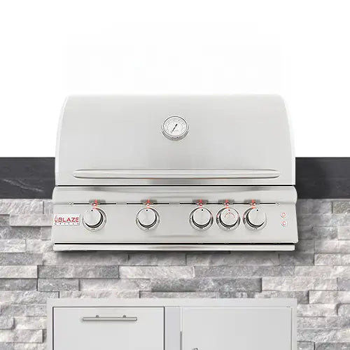A stainless steel BBQ gas grill with red lit control nobs is built into the outdoor kitchen counter top on a white background