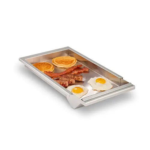 A stainless steel Fire Magic branded BBQ griddle accessory filled with delicious pancakes, eggs, and bacon for outdoor kitchens is presented on a white background
