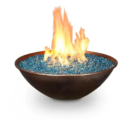 A copper fire bowl filled with blue turquoise fire glass on a white background
