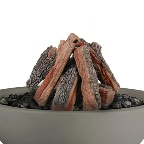 hand painted realistic gas logs are featured in a pile on top of a gray round fire pit filled with lava rock pieces