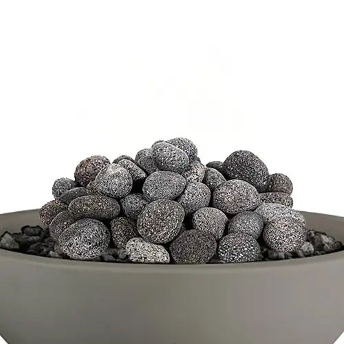lava rock is featured in a pile on top of a gray round fire pit filled with lava rock pieces