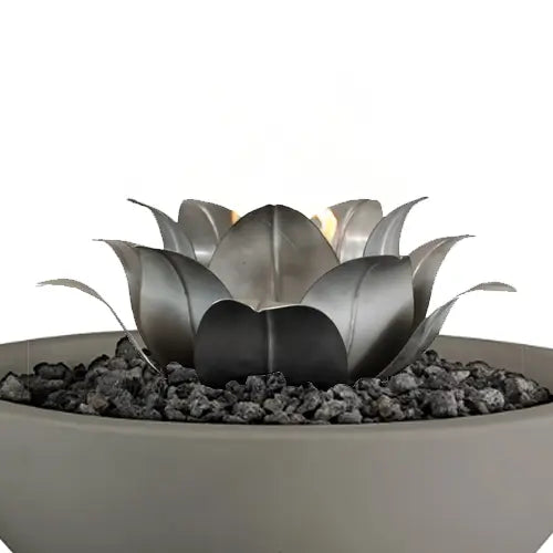 A stainless steel lotus fire pit decoration is featured in a pile on top of a gray round fire pit filled with lava rock pieces