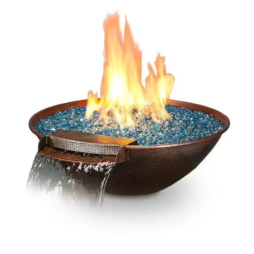 A copper fire and water bowl filled with blue turquoise fire glass and water spilling out onto a white background