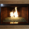 Elegant fireplace featuring a carved stone mantel, classic brick-lined interior, and a warm fire burning on a bed of sparkling fire glass, perfect for creating a cozy and luxurious ambiance