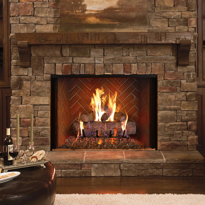 Installed view of the Fyreside Vented Live Oak Gas Log Set in a traditional stone fireplace, showcasing the realistic flame effect and authentic log texture. Ideal for natural gas fireplaces, this log set by RH Peterson Co. brings a warm and natural ambiance, perfect for enhancing any home’s aesthetic.