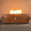Front view of the Gravity Moreno 48x32 rectangle copper fire pit with a strong flame, featuring a luxurious copper finish and modern design, ideal for outdoor fire pit setups