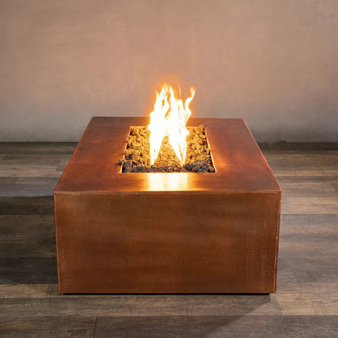Gravity Moreno 48x32 rectangle copper fire pit with a low flame, highlighting the elegant copper finish and modern design, perfect for a backyard outdoor fire pit settin