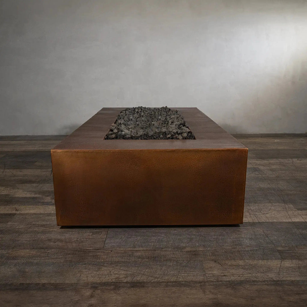 End view of the Gravity Moreno 72x38 copper fire pit by Starfire Designs, highlighting the elongated rectangular shape and rustic copper finish