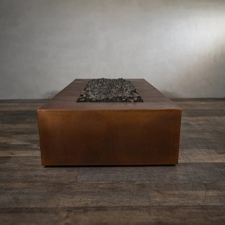End view of the Gravity Moreno 72x38 copper fire pit by Starfire Designs, highlighting the elongated rectangular shape and rustic copper finish
