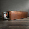 Side view of the Gravity Moreno 72x38 copper fire pit by Starfire Designs, featuring the extended hidden propane tank drawer with a hammered copper finish
