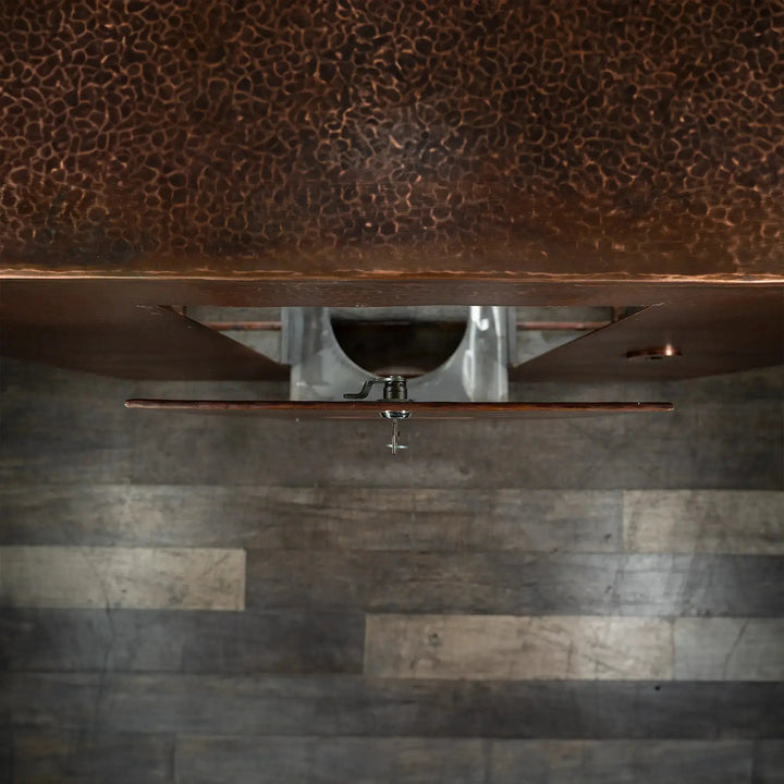 Top view of the Gravity Moreno copper fire pit by Starfire Designs showing the detail of the opened propane tank door with hammered copper finish