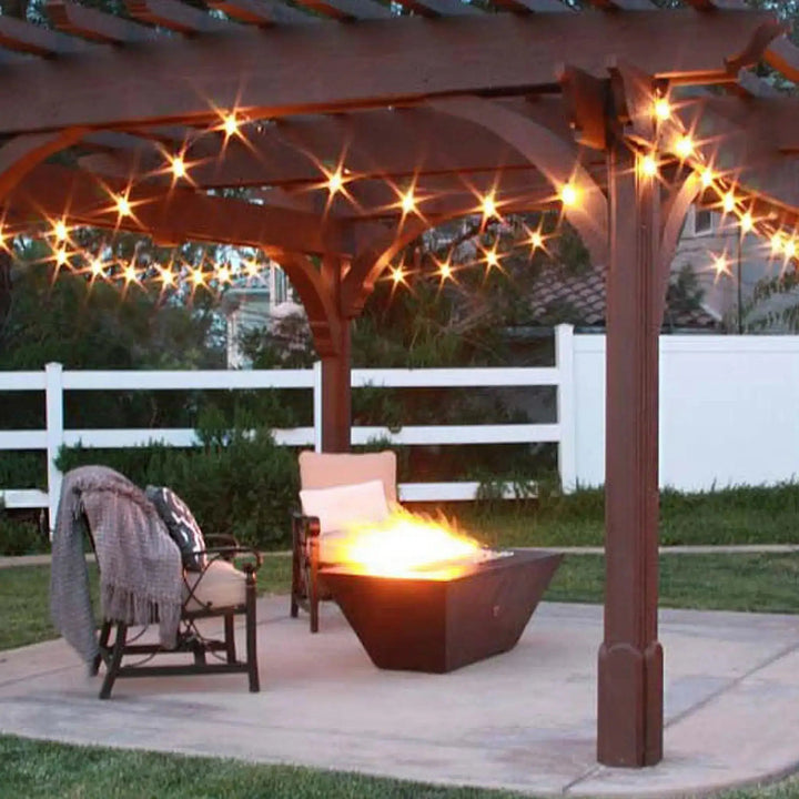 Largo Moreno 60-inch x 26-inch Rectangle Copper Fire Pit under a pergola, warm and inviting outdoor setting with string lights
