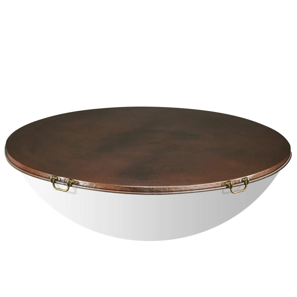Close-up of the brass handles on the Moreno 60-inch round copper fire pit lid by Starfire Designs. The sturdy brass handles provide easy lifting, while the hammered copper lid offers protection for large fire bowls and outdoor fire pits. Perfect for luxury outdoor fire tables and backyard setups, this lid combines functionality and aesthetics
