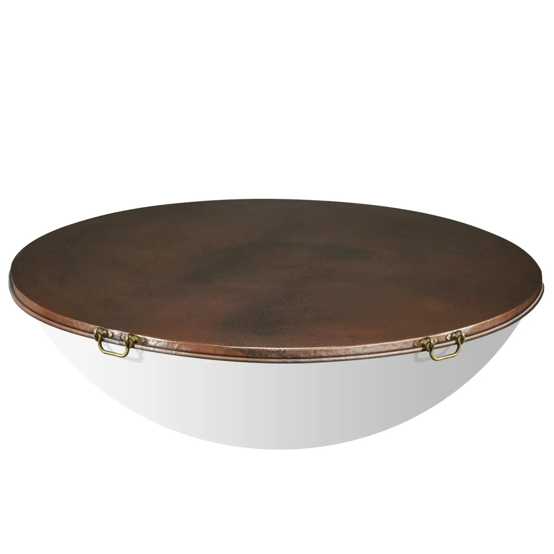 Close-up of the brass handles on the Moreno 60-inch round copper fire pit lid by Starfire Designs. The sturdy brass handles provide easy lifting, while the hammered copper lid offers protection for large fire bowls and outdoor fire pits. Perfect for luxury outdoor fire tables and backyard setups, this lid combines functionality and aesthetics