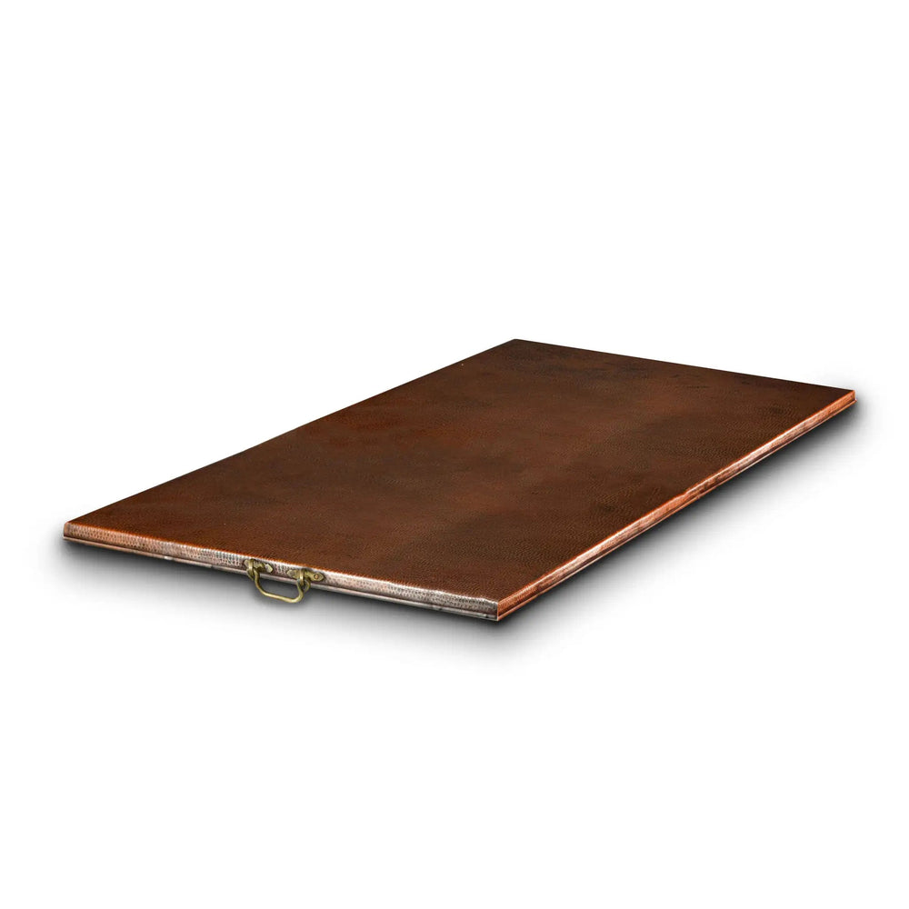 Moreno 60-inch x 26-inch rectangular copper fire pit lid with a flat panel design, crafted from high-quality hammered copper. This elegant lid offers protection for outdoor fire bowls and fire pits, while the sturdy brass handles provide ease of use. Ideal for luxury outdoor fire tables, patio setups, and modern backyard fire pits, this copper lid adds both style and durability