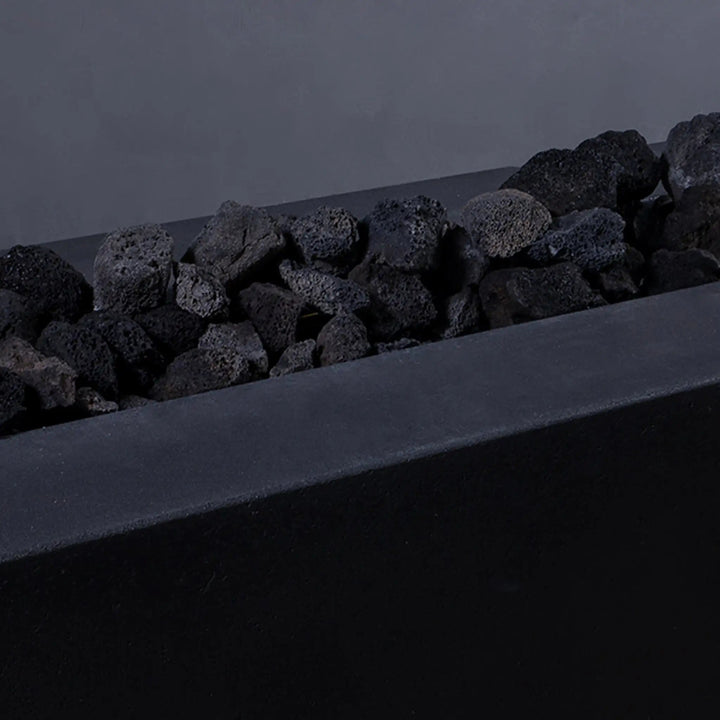 Close-up of medium volcanic lava rocks without flames in a fire pit. These 2-3 inch porous stones are perfect for fire pits, offering durability, superior heat retention, and a visually appealing natural texture.