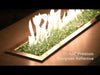 A modern linear fire feature showcases the rich, vibrant glow of 1/4" Evergreen Reflective Fire Glass by American Fire Products, with lush green tones and mirrored facets dancing beneath golden flames—perfect for adding fresh, organic elegance to any outdoor living space.
