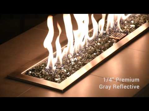 Modern fire feature showcasing American Fire Products 1/4" Gray Reflective Fire Glass in action, with cool silver-gray glass pieces shimmering beneath a lively flame for a sleek, contemporary outdoor ambiance.