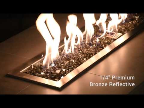 Video of American Fire Products 1/4" Bronze Reflective Fire Glass dancing beneath vibrant flames in a modern fire pit—highlighting the glass’s rich, smoky hue and glimmering reflective finish that adds warmth and elegance to any outdoor setting.