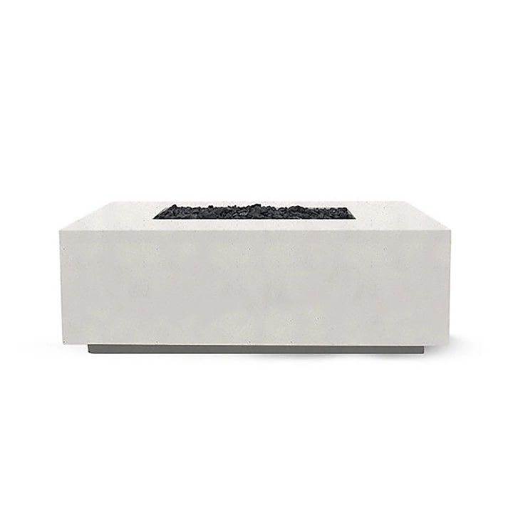The Prism Hardscapes Portos 58" Propane Fire Table in ultra-white is showcased in a modern outdoor setting, creating a striking contrast with nature. This bright and contemporary fire table offers a clean, minimalist design with a smooth concrete surface. It provides a powerful propane flame that makes it ideal for both commercial fire pits and backyard fire pit areas. This fire table is perfect for those looking for a sleek and modern fire pit for their patio or outdoor space.