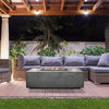 Prism Hardscapes Portos 68 Propane Fire Table in an outdoor patio setting at night. The fire table is surrounded by comfortable seating, creating a cozy and stylish atmosphere. Ideal for those looking for a modern propane fire pit for their outdoor space, backyard fire pit, or patio fire pit.