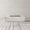 Prism Hardscapes Tavola 1 Gas Fire Pit in pewter, displayed in a minimalist studio environment. The fire pit’s rectangular design combined with the subtle grey finish creates an elegant yet robust look. Perfect for modern outdoor spaces, this fire pit provides ample heat and ambiance with its high-powered gas burner. The pewter finish complements a variety of outdoor furniture styles. 
