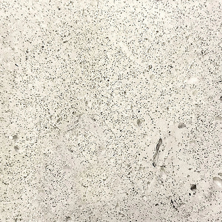 A detailed swatch of the Prism Hardscapes Tavola 3 Gas Fire Pit in natural gray. The light gray concrete texture showcases its raw, unpolished appearance, giving a natural, timeless look that blends seamlessly with outdoor environments. Perfect for fire pits in residential or commercial spaces, offering a neutral, versatile color option.