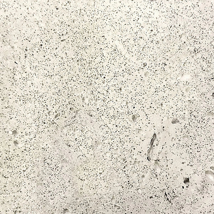 Closeup of the Prism Hardscapes Tavola 4 Gas Fire Pit swatch in natural color. This natural gray concrete finish emphasizes the simplicity and elegance of the material, ideal for minimalist and contemporary outdoor spaces. The surface’s textured details add to the fire pit’s robust durability, making it perfect for year-round use in gardens or patio areas