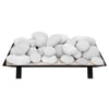 Top view of the Rasmussen Vented FireStones in white, featuring multiple smooth, round fire stones stacked on a fire grate. Ideal for outdoor fire pit designs, these vented fire stones offer a contemporary, clean look. Their white color complements a modern or minimalist outdoor setting, adding style and functionality to fire pits or fire tables.