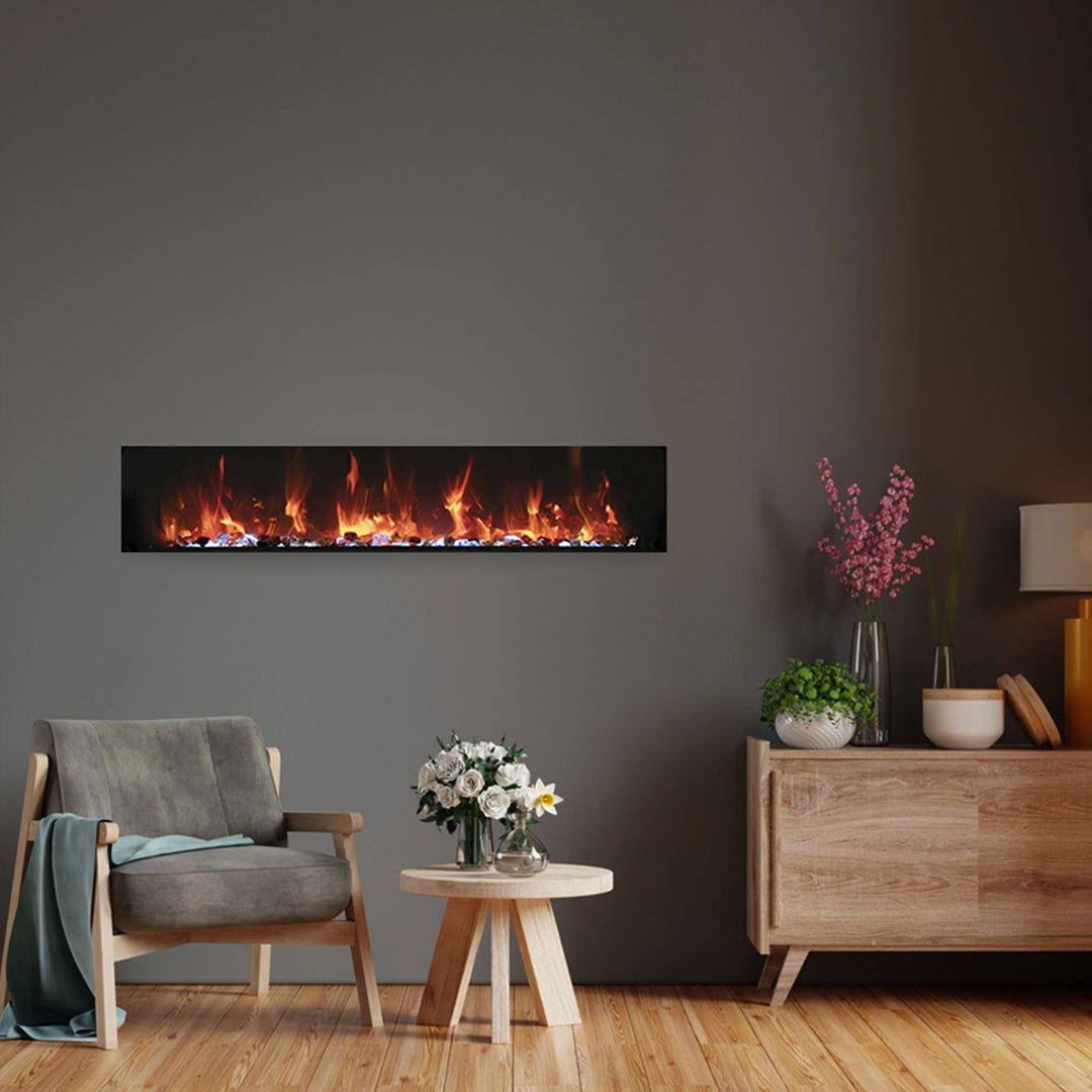 Remii Extra Slim built-in electric fireplace integrated into a cozy living room setting. The sleek design enhances the ambiance with vivid orange flames and glowing embers, fitting perfectly into modern decor styles for both indoor and covered outdoor use.