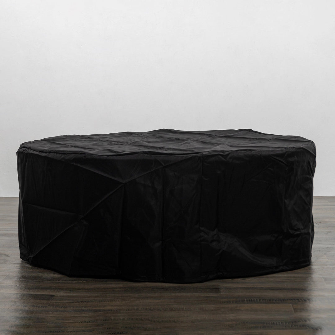 The Starfire Designs Beton 42 Inch Graphite Round Concrete Natural Gas Fire Pit fully covered with a weather-resistant black protective cover, offering superior protection against the elements while maintaining its stylish outdoor appeal.