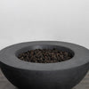 The Starfire Designs Beton 42 Inch Graphite Round Concrete Natural Gas Fire Pit filled with high-quality black lava rocks, creating a natural and modern outdoor ambiance with its sturdy concrete construction and sophisticated graphite finish.