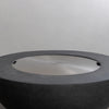 The Starfire Designs Beton 42 Inch Graphite Round Concrete Natural Gas Fire Pit covered with a seamless stainless-steel lid, emphasizing its protective feature and sleek, minimalist design for outdoor functionality and style.