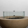 The Starfire Designs Beton 42 Inch Sand Round Concrete Natural Gas Fire Pit equipped with a glass wind guard. This elegant addition protects the flames from strong winds while maintaining safety and enhancing the modern fire pit design. A must-have for luxury fire pits.
