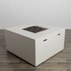 The Starfire Designs Beton 42" White Square Hidden Propane Tank Gas Fire Pit in a side-angle shot, highlighting its modern geometric design and built-in portability handles. 