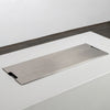 A close-up of the Starfire Designs Beton 55" White Rectangle Hidden Propane Tank Gas Fire Pit with the stainless steel burner cover in place. The cover sits flush on the rectangular concrete frame, offering a clean and minimalist aesthetic. This protective cover is perfect for shielding the burner when not in use.