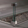 Close-up of Starfire Designs Beton Square Glass Wind Guard corner detailing. Durable tempered glass panels held by silver brackets ensure stability and safety. Ideal for windy environments, this accessory enhances the functionality and design of modern fire pits and tables.
