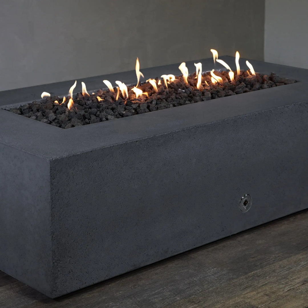 Corner view of the Starfire Designs Concrete Rustic 60" x 32" Rectangle Gravity Gas Fire Pit in Graphite. The durable concrete construction and graphite color give this fire pit a timeless, modern look, making it the perfect addition to outdoor living spaces