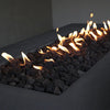 Detailed view of the lava rocks and flames on the Starfire Designs Concrete Rustic 60" x 32" Rectangle Gravity Gas Fire Pit in Graphite. The combination of black lava rocks and vivid flames creates a dramatic focal point for any outdoor setting, providing both warmth and ambiance