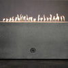 Starfire Designs Concrete Rustic Gravity Gas Fire Pit in natural gray, 60" x 32", with flames burning along the stainless steel burner. The long rectangular shape and smooth concrete finish bring a modern yet rustic feel to any outdoor area. The dancing flames provide a warm and inviting atmosphere. Best for residential and commercial outdoor use