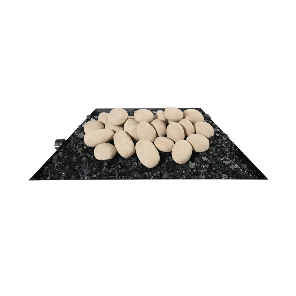 A side view of a tray of 24 beige fire pebbles placed on top of black fire glass, highlighting the smooth, natural texture of the ceramic stones. These fire-resistant pebbles are designed to enhance the aesthetic of outdoor fire pits, providing a soft, neutral color that complements various fire pit styles. Perfect for creating a natural yet modern fire feature