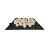 A side view of a tray of 24 beige fire pebbles placed on top of black fire glass, highlighting the smooth, natural texture of the ceramic stones. These fire-resistant pebbles are designed to enhance the aesthetic of outdoor fire pits, providing a soft, neutral color that complements various fire pit styles. Perfect for creating a natural yet modern fire feature