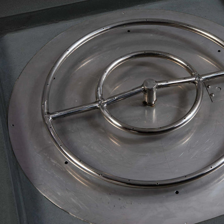 Close-up of the stainless steel burner inside the Starfire Designs Gravity 36-inch Square Concrete Gas Fire Pit in Graphite. The burner is designed for efficiency and even flame distribution, ensuring optimal performance for outdoor gatherings. The fire pit is a premium choice for modern outdoor living spaces.