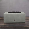 Top-down view of the Starfire Designs Gravity 36-inch Square Concrete Gas Fire Pit in natural gray with black lava rocks, showcasing the sleek square design and high-quality construction, perfect for any modern patio or backyard setup