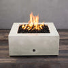 A top-down view of the Starfire Designs Gravity 36" Square Concrete Gas Fire Pit in white, highlighting the vivid flames over the lava rock. The crisp white concrete finish provides a contemporary look, ideal for luxury outdoor settings